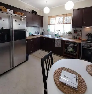 a large kitchen with a table and a refrigerator at Hope house Kavouri in Athens