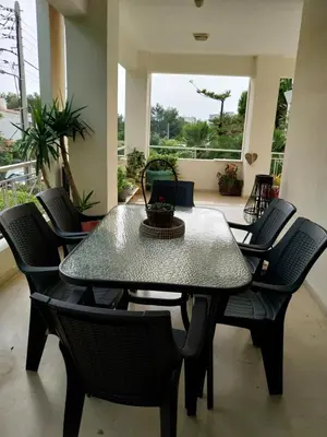 a dining table and chairs in a room with a window at Hope house Kavouri in Athens