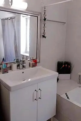 a white bathroom with a sink and a bath tub at Hope house Kavouri in Athens