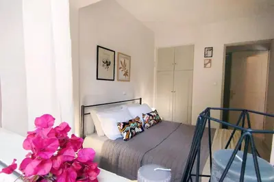 a bedroom with a bed with pink flowers on it at Garden Apartment with BBQ in the Athenian Riviera in Athens