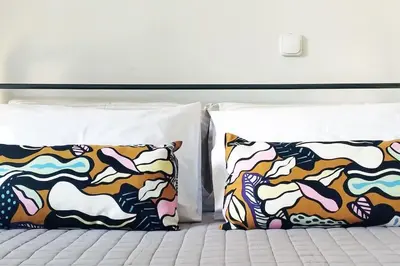 two pillows are sitting on a bed with at Garden Apartment with BBQ in the Athenian Riviera in Athens
