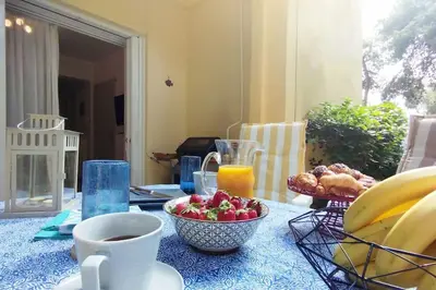 a table with a bowl of fruit and a cup of coffee at Garden Apartment with BBQ in the Athenian Riviera in Athens