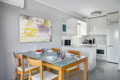 a kitchen with a dining room table and chairs at South Blue Sea View Apartment in Athens