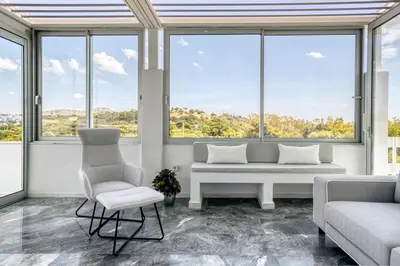 a living room with a couch and chairs and windows at South Blue Sea View Apartment in Athens