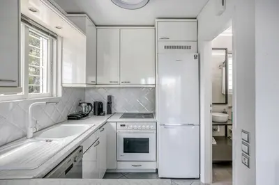 a white kitchen with a sink and a refrigerator at South Blue Sea View Apartment in Athens