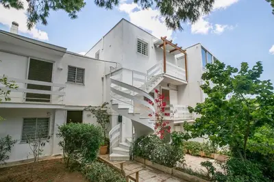 a white building with stairs in front of it at South Blue Sea View Apartment in Athens