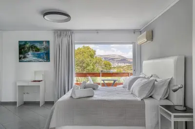 a bedroom with a bed and a large window at South Blue Sea View Apartment in Athens
