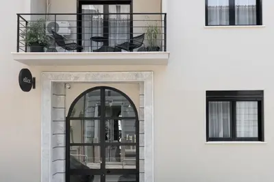 a balcony with black chairs on a white building at Elliot Neapoli, Athens in Athens