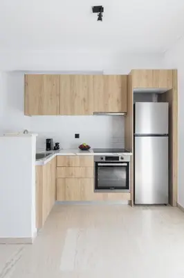a kitchen with wooden cabinets and a stainless steel refrigerator at Elliot Neapoli, Athens in Athens