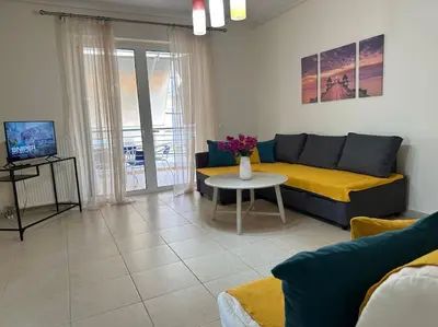 a living room with a couch and a table at Riviera beach, seaside spacious apt. in Anavissos