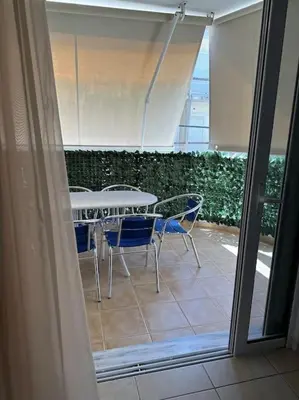 a patio with a table and chairs on a balcony at Riviera beach, seaside spacious apt. in Anavissos