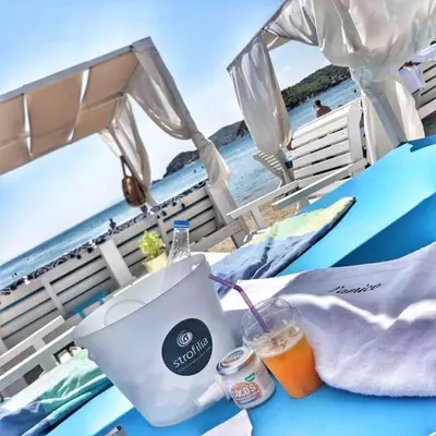a table with a drink on the beach at Riviera beach, seaside spacious apt. in Anavissos