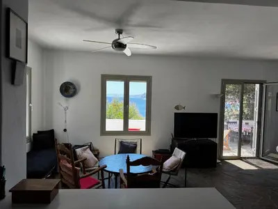 a living room with a table and chairs at Attica Vacation Home in Dhaskalión