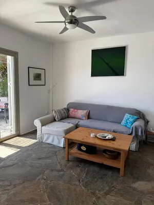 a living room with a couch and a table at Attica Vacation Home in Dhaskalión