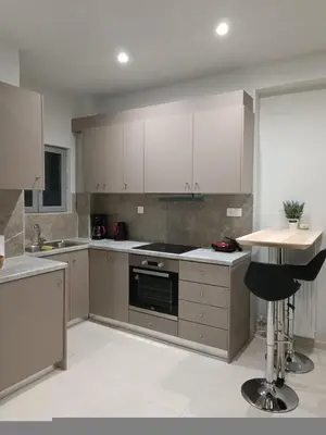 a kitchen with white cabinets and a stove top oven at Embassy Apartment - I2 in Athens