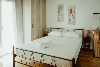 a bedroom with a bed with white sheets at Aria apartment in Athens