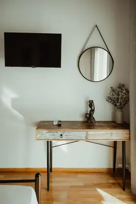a table with a mirror and a tv on a wall at Aria apartment in Athens