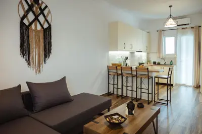 a living room with a couch and a kitchen at Aria apartment in Athens