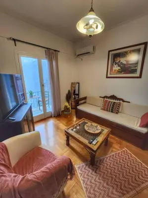 a living room with a couch and a coffee table at Ilyssos - Boho Stylish apt- Hilton Area Athens in Athens