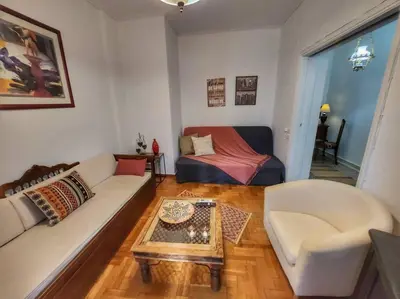 a living room with a couch and a table at Ilyssos - Boho Stylish apt- Hilton Area Athens in Athens
