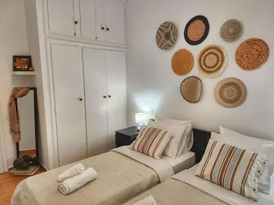 a bedroom with two beds and hats on the wall at Ilyssos - Boho Stylish apt- Hilton Area Athens in Athens
