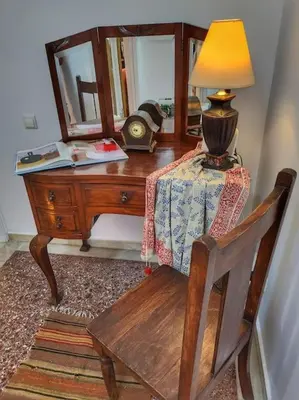 a wooden desk with a lamp and a table with a chair at Ilyssos - Boho Stylish apt- Hilton Area Athens in Athens