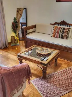a living room with a couch and a coffee table at Ilyssos - Boho Stylish apt- Hilton Area Athens in Athens