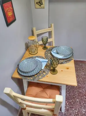 a wooden table with plates and dishes on it at Ilyssos - Boho Stylish apt- Hilton Area Athens in Athens
