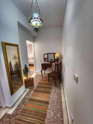 a hallway with a room with a mirror and a table at Ilyssos - Boho Stylish apt- Hilton Area Athens in Athens