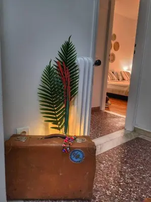 a suitcase sitting on the floor with a plant at Ilyssos - Boho Stylish apt- Hilton Area Athens in Athens