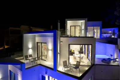 a view of a house at night at White Cliff Luxury Suites in Porto Rafti