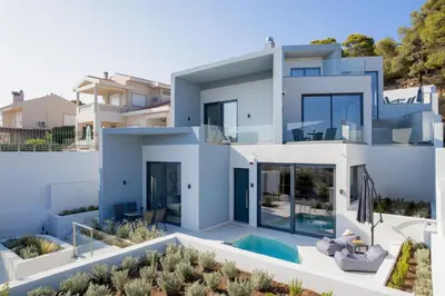 a large white house with a swimming pool at White Cliff Luxury Suites in Porto Rafti