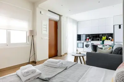 a living room with a bed and a kitchen at The Charm Studio in Glyfada in Athens