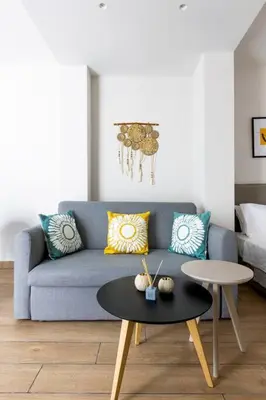 a living room with a blue couch and a table at The Charm Studio in Glyfada in Athens