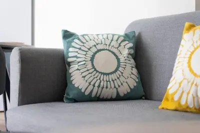 a gray couch with two pillows on it at The Charm Studio in Glyfada in Athens