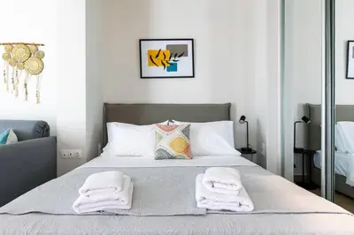 a bedroom with a bed with two towels on it at The Charm Studio in Glyfada in Athens