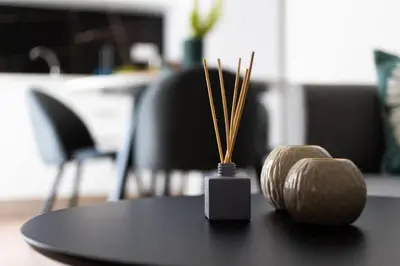 a black table with a vase with inciatediatediatediatediatediatediated at The Charm Studio in Glyfada in Athens