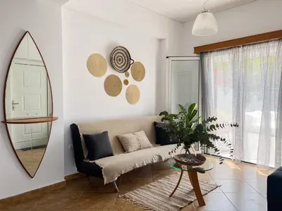 a living room with a couch and a mirror at My Porto Villa in Porto Rafti