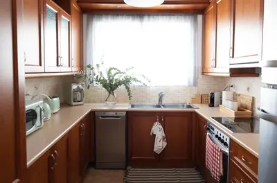 a kitchen with wooden cabinets and a sink and a window at My Porto Villa in Porto Rafti