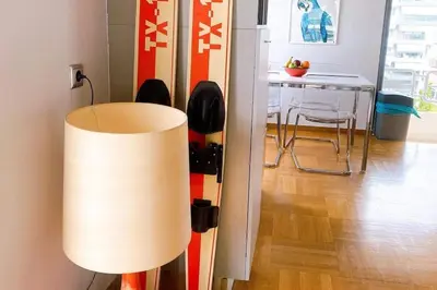 a lamp in a living room with a table with chairs at Superior Penthouse in Athens Riviera in Athens
