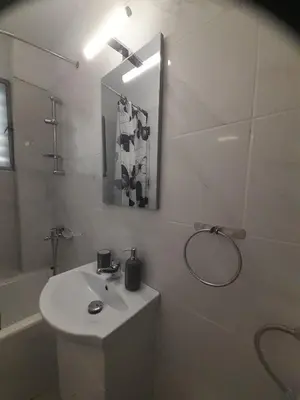 a white bathroom with a sink and a shower at Central Apartment in Athens
