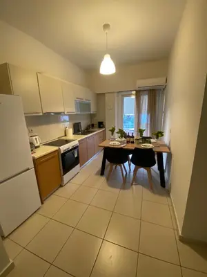 a kitchen with a table and chairs and a refrigerator at Athina’s apartment in Athens