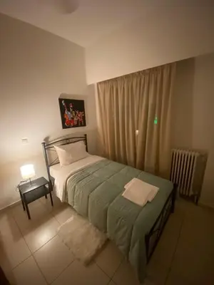 a small bedroom with a bed and a window at Athina’s apartment in Athens