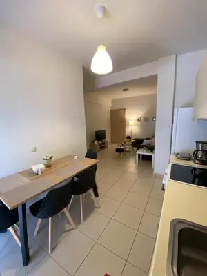 a kitchen with a wooden table and chairs in a room at Athina’s apartment in Athens
