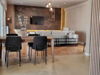 a dining room with a table and chairs and a couch at Lycabettus Vista Luxury Suite in Athens