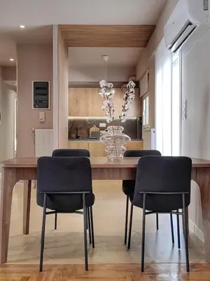 a dining room table with chairs and a vase of flowers at Lycabettus Vista Luxury Suite in Athens