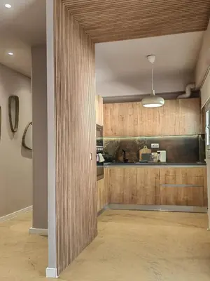 a kitchen with wooden cabinets and a counter top at Lycabettus Vista Luxury Suite in Athens