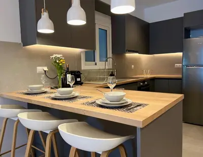 a kitchen with a large island with a table and chairs at AgiasFoteinis20 in Athens