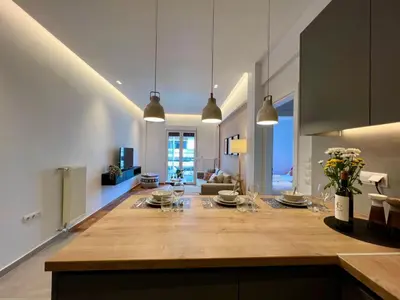 a kitchen and living room with a large wooden table at AgiasFoteinis20 in Athens