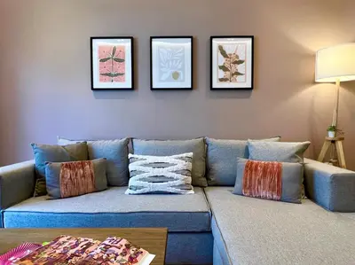 a living room with a blue couch with pillows at AgiasFoteinis20 in Athens